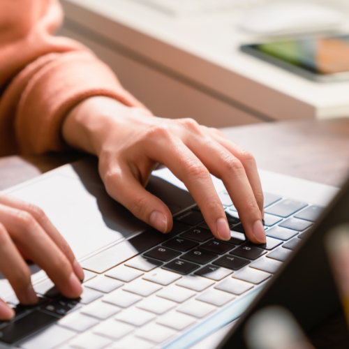 Hands typing on a laptop.